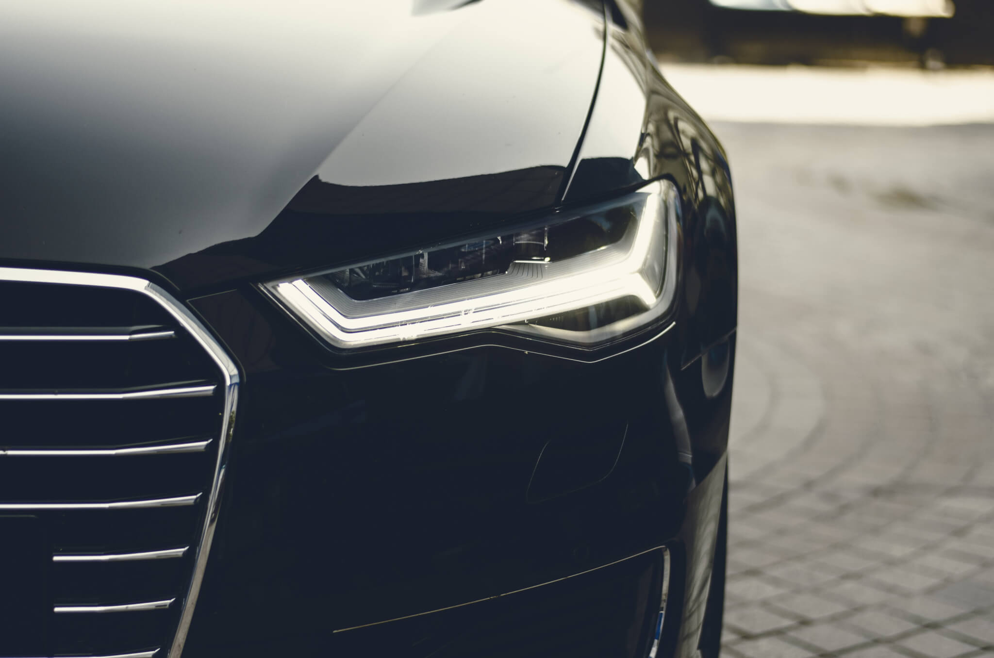 Close up of headlight and hood of black car